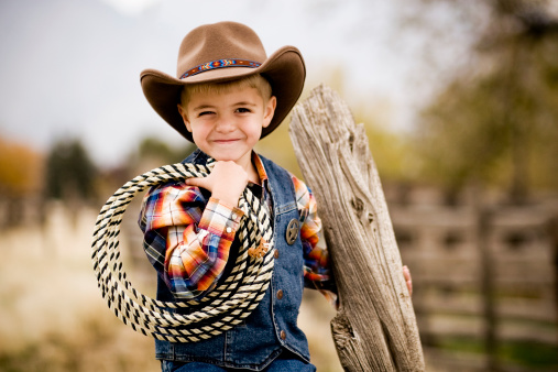 A young cowboy on the fence.