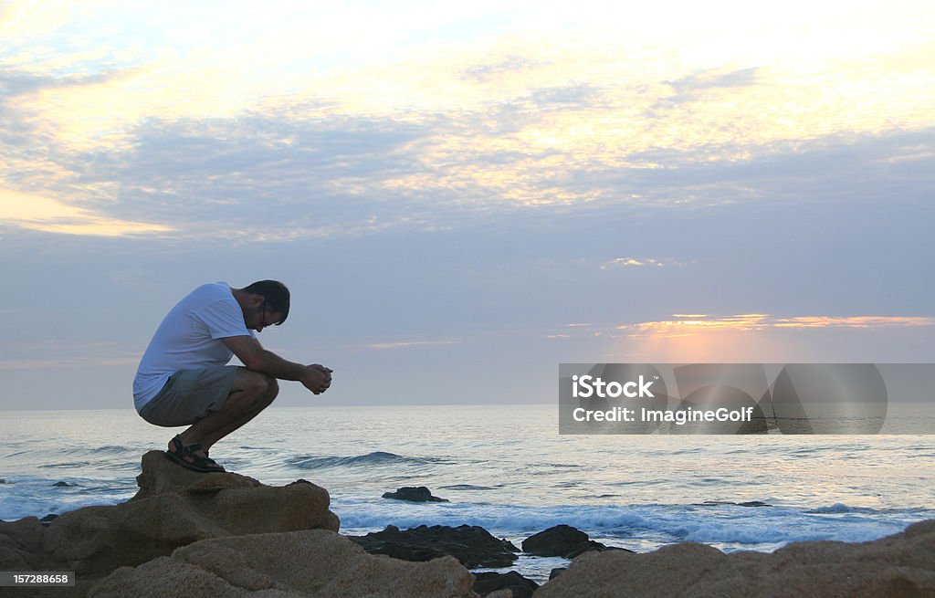 若い白人男性誇る海のそば - 祈るのロイヤリティフリーストックフォト