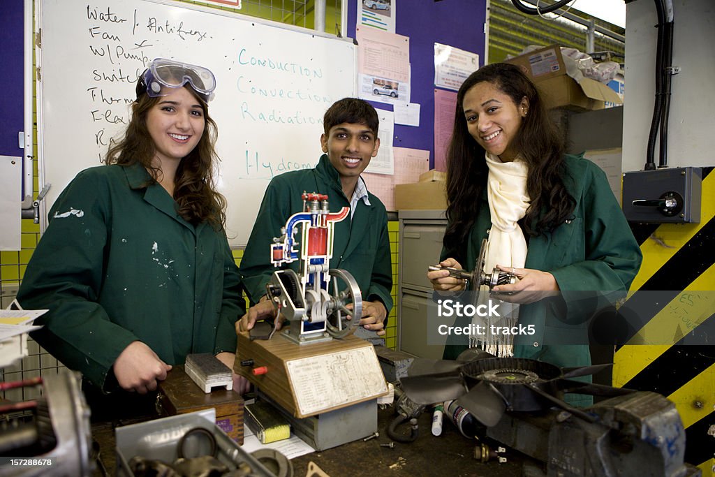 Adolescente alunos: Estagiário mecânica sorrindo enquanto aprendem a trade - Foto de stock de Engenharia royalty-free