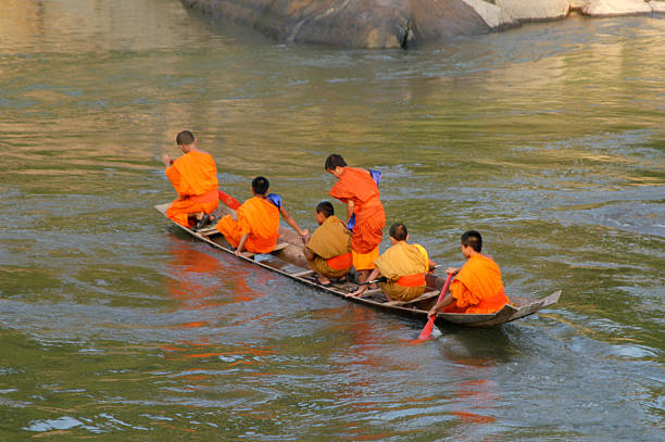 буддийские монахи сделать духовное путешествие по реке жизни - luang phabang laos thailand mekong river стоковые фото и изображения