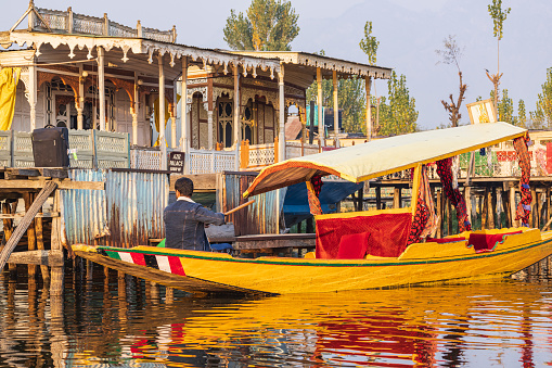 Rainawari, Srinagar, Jammu and Kashmir, India. October 24, 2022. Man paddling a traditional shikara boat at Dal Lake.