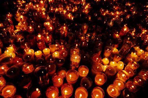Hundreds of candles on floor of church.