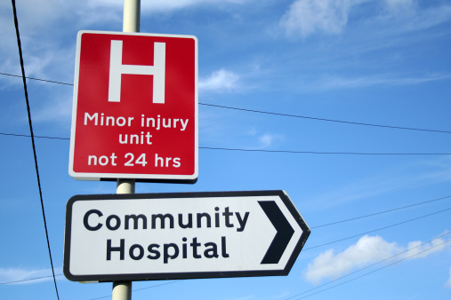 Hospital and minor injuries unit sign against a bright blue sky
