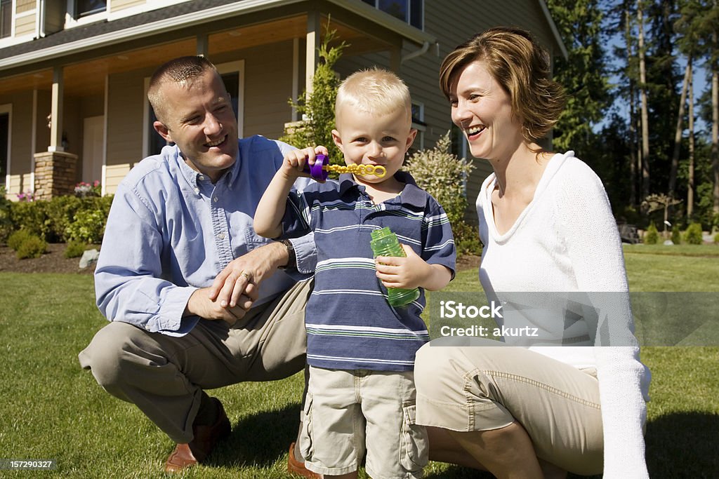 Famille jouant dans la cour avec fils de souffler bulles - Photo de 12-17 mois libre de droits