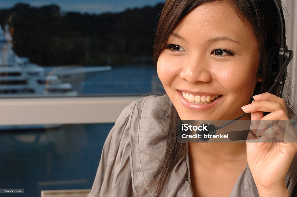 Service mit einem Lächeln-asiatischen Modell - Lizenzfrei Am Telefon Stock-Foto