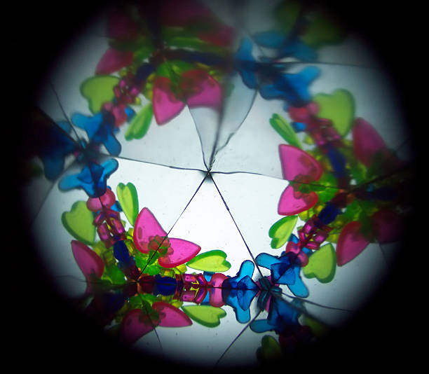 View inside a dimestore kaleidescope. Focus is on the real (non-reflection) objects towards the lower left.