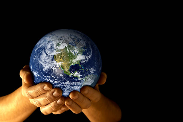 Man with planet earth in hands Earth in man's hands isolated on black. Much space for copy. origins stock pictures, royalty-free photos & images