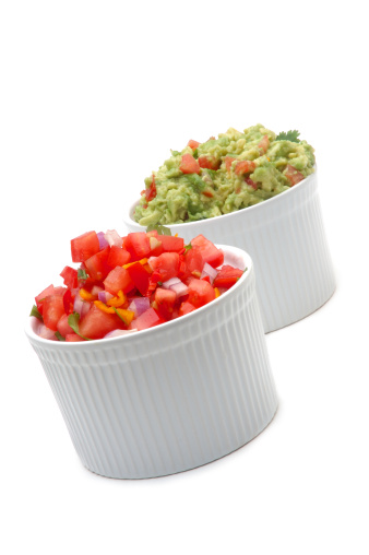 Two bowls of fresh salsa and guacamole dips, ready to party.