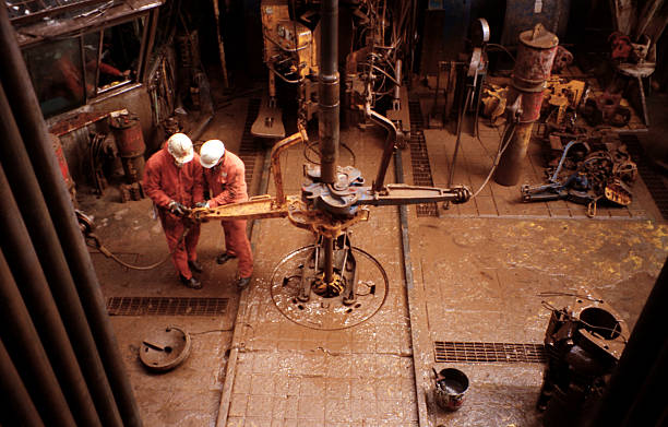 два roughnecks действовать в нефтяная платформа платформа drill этаже - нефтяник стоковые фото и изображения
