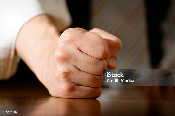 Closeup Of A Fist Resting On A Wooden Surface Stock Photo - Download Image Now - Fist, Anger, Displeased