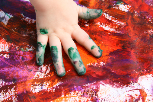 Children's master class in drawing, the child makes a handprint with paint.