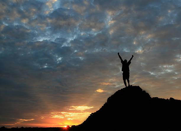 istock Unrecognizable Man Standing on Mountain Top With Arms Raised 157293463