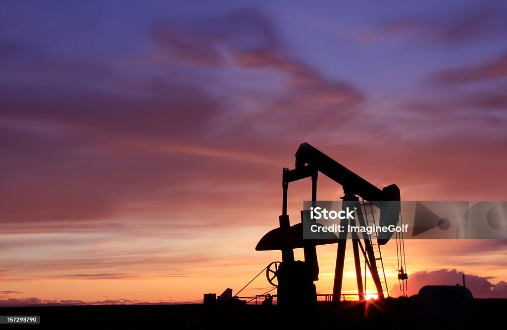 Silhouette of an Oil Industry Pumpjack in Canada A pumpjack on the prairie. Oil industry. Silhouette of an oil rig on the plains. Alberta, Canada. Image can be used for fuel, energy, gas, natural gas, fossil fuel, pollution, oil sands, and anything oil or export related.  Lever Stock Photo