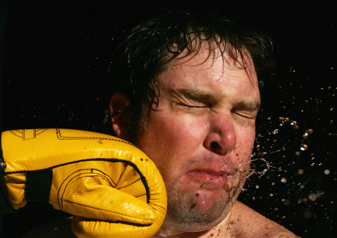 Sweat and spit flies as a man is punched in the face