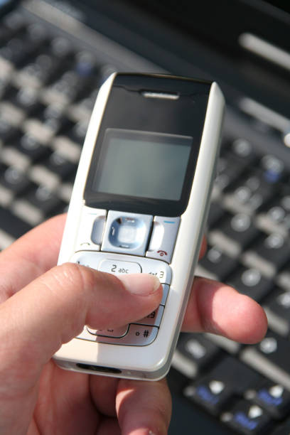 istock man holding mobile phone,laptop in background 157294023