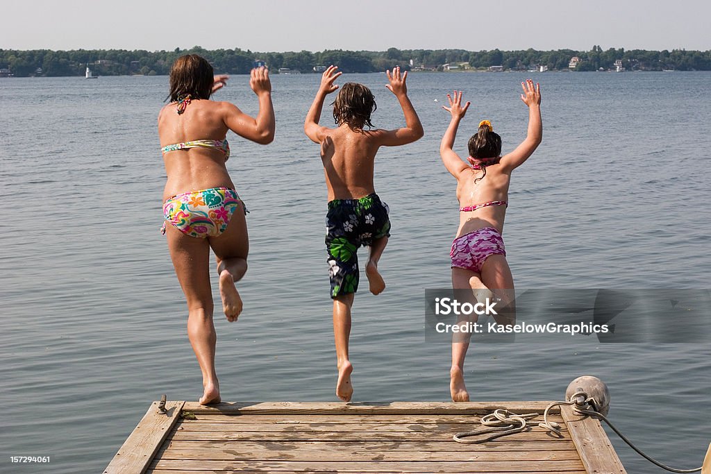 Kinder springen auf einem Dock - Lizenzfrei Fluss Stock-Foto