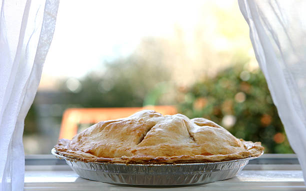 Apple Pie  - Cooling in Window Photo of an hot apple pie cooling on a window ledge. cooling rack photos stock pictures, royalty-free photos & images