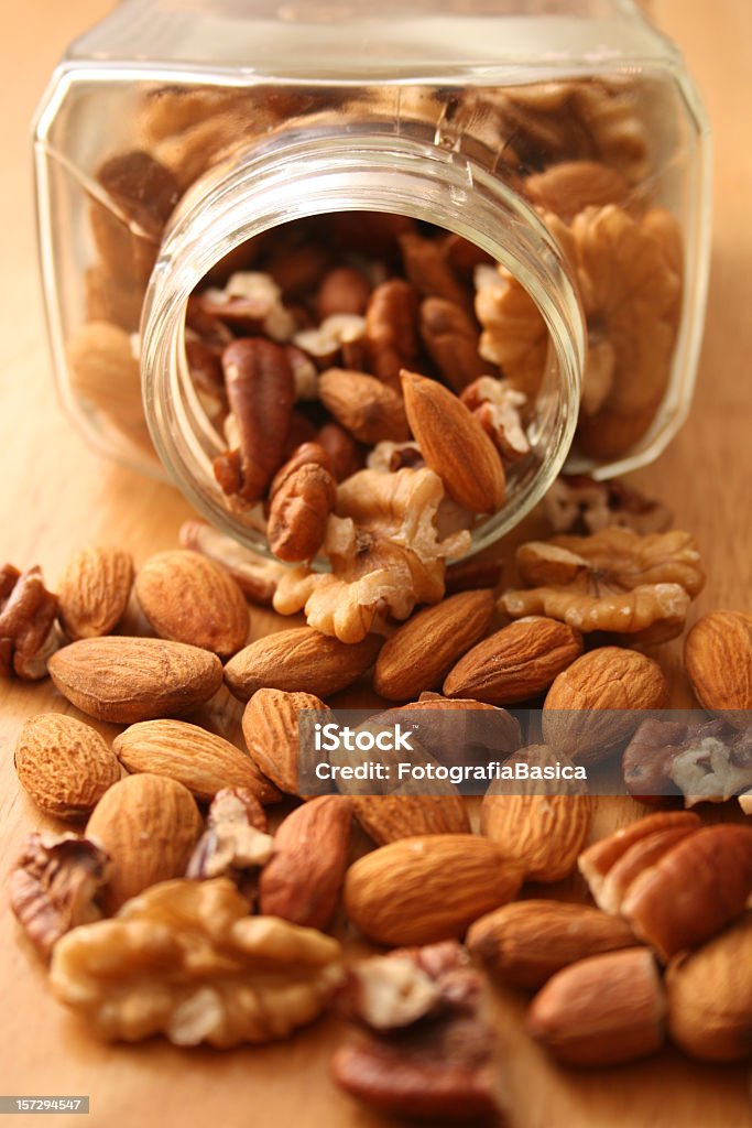 Assorted nuts Variety of nuts popping out from glass jar Walnut Stock Photo