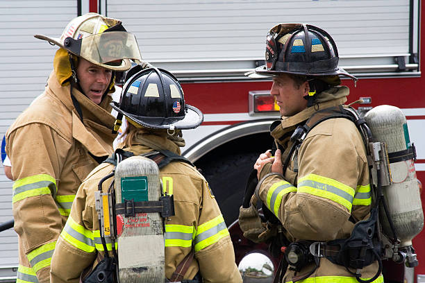 bomberos hablar de estrategias - casco protector fotos fotografías e imágenes de stock