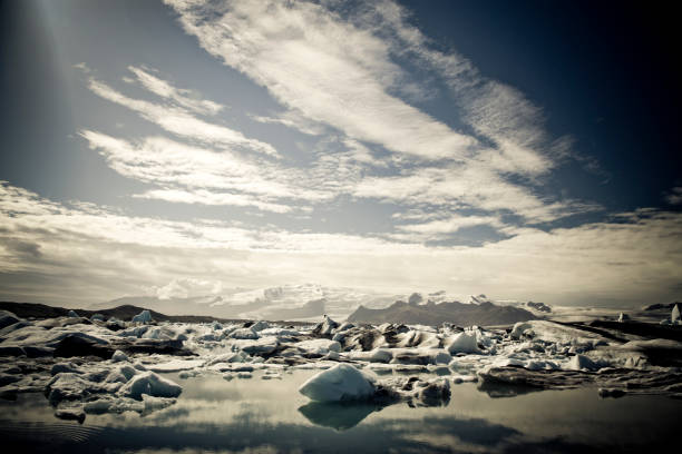 Raw Nature Icebergs Series III icebergs melting in the north atlantic sea at the vatnajokull glacier, Iceland. Series of 4 similiar style-edited nature shots. iceberg dramatic sky wintry landscape mountain stock pictures, royalty-free photos & images