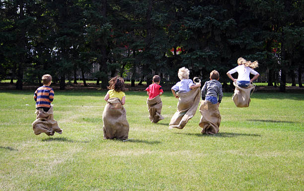 бег в мешках - child playing sack race sports race стоковые фото и изображения