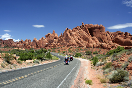 Two motorcycles traveling through Arches National Park in Utah.
