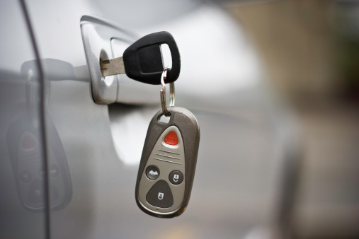 Car key with remote control inserted in car door.