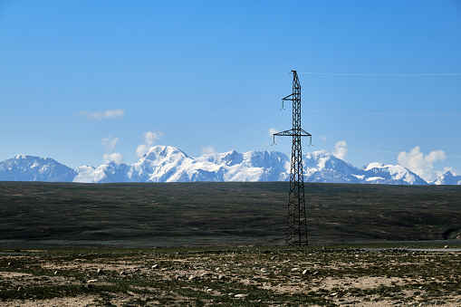 Electricity pilon in highland valley in Tien Shan mountains. Arabel plateau