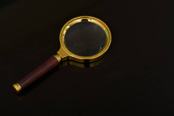 istock Magnifying glass isolated on a black background. 1572979930