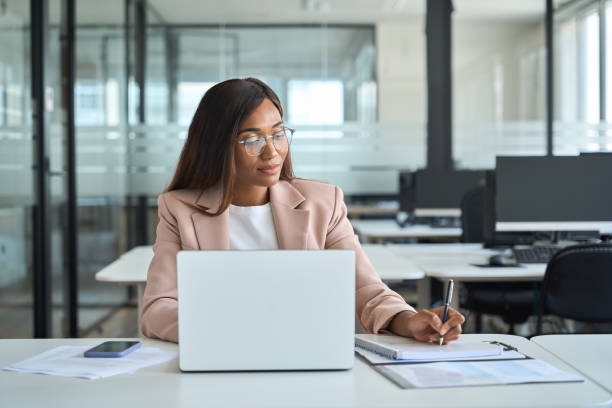 istock Busy professional business woman executive working in office writing notes. 1572980497