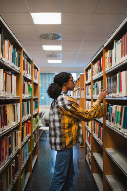 istock Smiling college girl in the library 1572981738