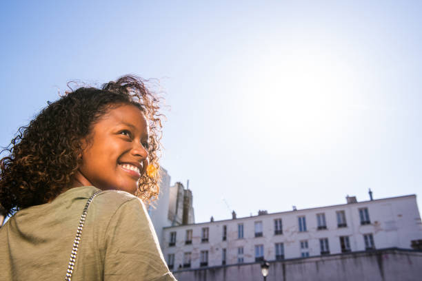 Close up portrait from behind young woman looking over shoulder and smiling
