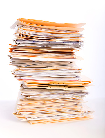 A stack of paperwork files against a white background.