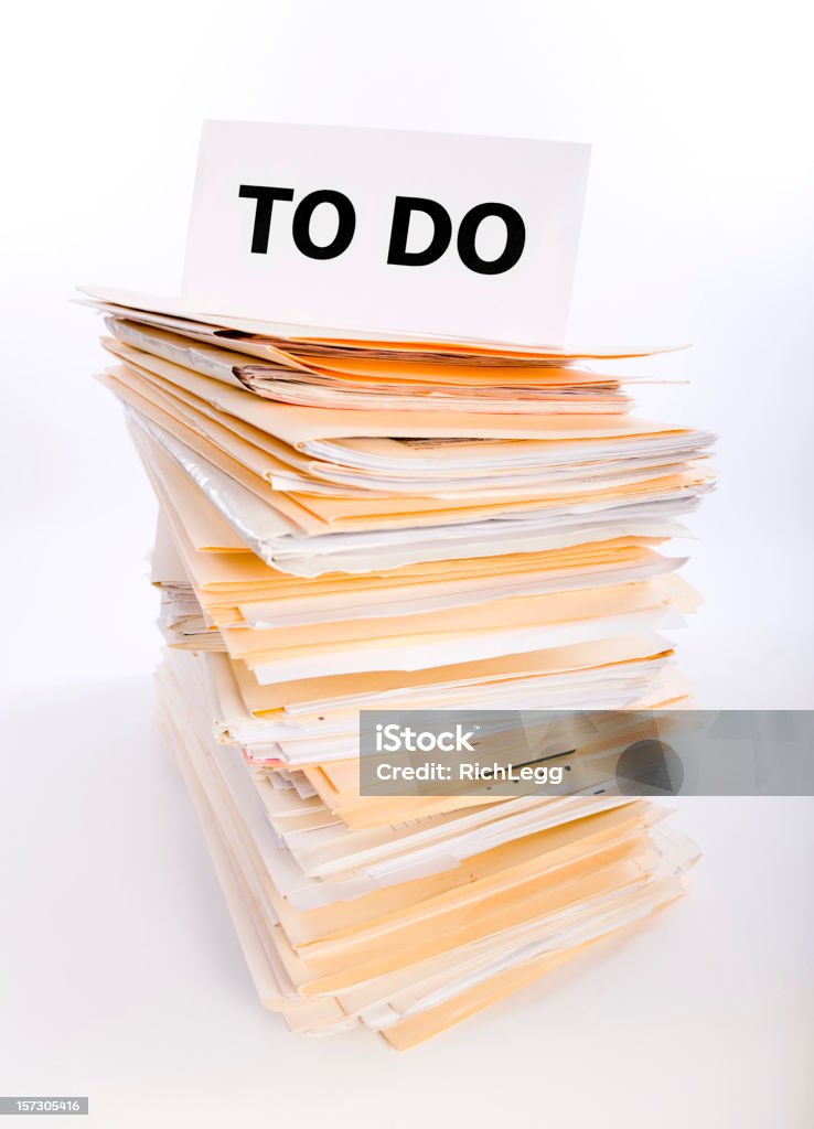 Paperwork Overload A stack of paperwork files underneath a "TO DO" sign. Excess Stock Photo