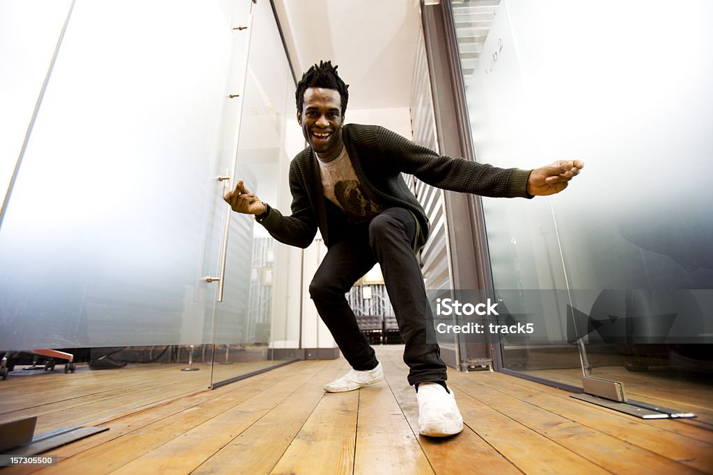 Make dancing toward a camera on the ground A relaxed and fun moment from a confident character creeping up on the low-angle camera in a contemporary creative office environment. Dancing Stock Photo