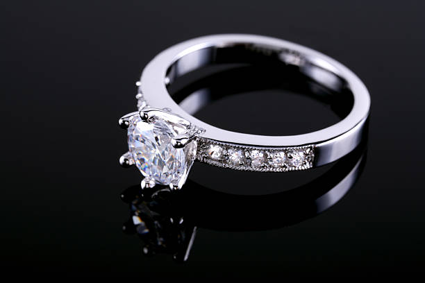 diamond ring on a reflective surface - elmas yüzük stok fotoğraflar ve resimler