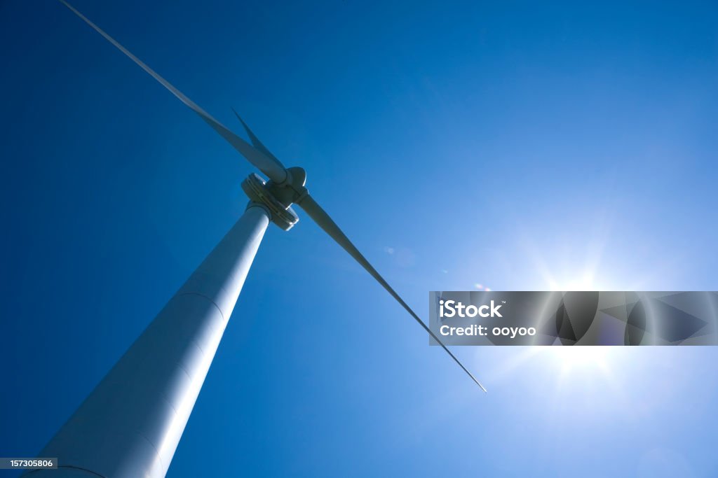 Turbina de viento con el sol detrás - Foto de stock de Aerogenerador libre de derechos