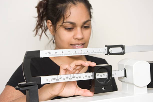 istock woman on medical weight scale 157305909