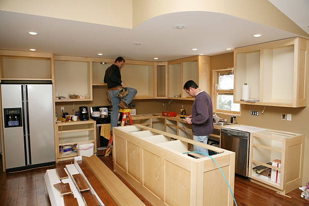 Kitchen Remodel Cabinet maker installing custom made kitchen island and cabinets, while electrician installs in-cabinet lighting.
Very shallow DOF quickly drops off to nice soft focus. kitchen remodel stock pictures, royalty-free photos & images