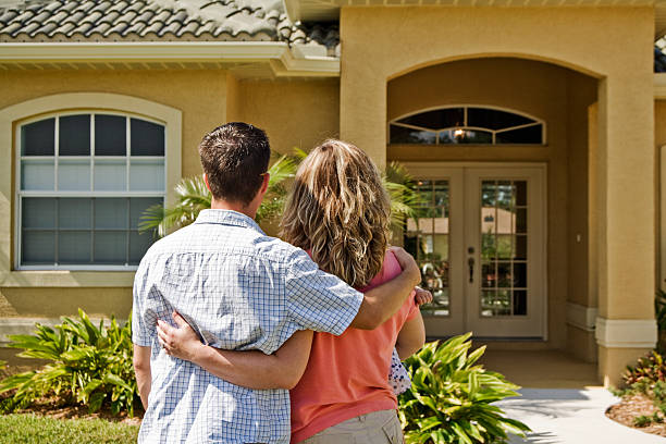 istock Young couple holding each other in front of a house 157305949