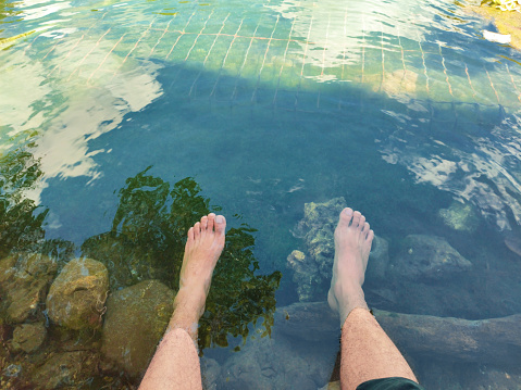 Feet in a pool full of water