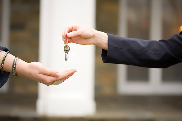 istock handing keys over in front of house 157307300