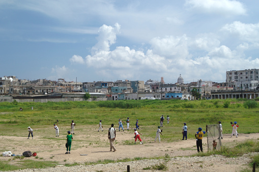 Cubans playing baseball beisbol on a hot afternoon in a typically run-down sports field in the center of Havana, Cuba