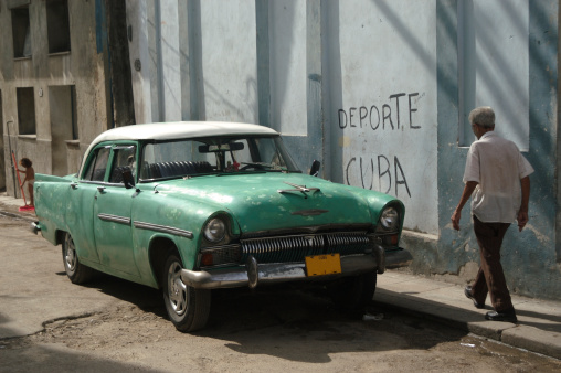 Classic American car in green sits parked on Havana street