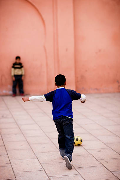 Children, team and playing soccer on field, sport and exercise, group of people outdoor during game. Teamwork, fitness and young athlete kids, goal keeper and players on sports ground with training