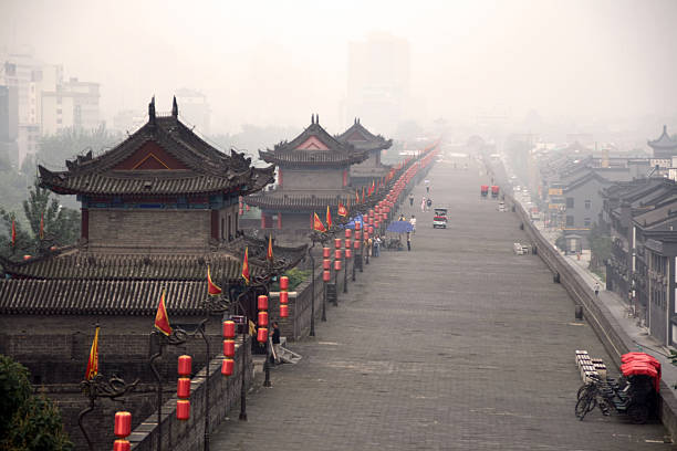 Red lanterns and flag on top of ancient Xiâan City Wall, blue sky background, China