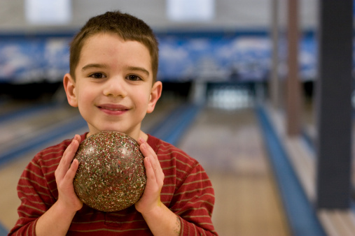 5-year-old boy plays Duckpin Bowling. Duckpin bowling is a type of tenpin bowling popular in the Eastern US.