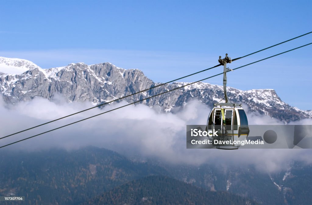 Cable Car Ascending in the Alps Cable-car transporting skiiers up to a mountain summit in the Alps. Overhead Cable Car Stock Photo