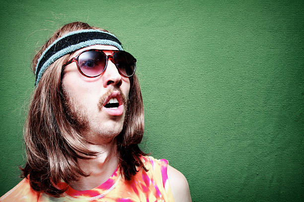 Surprised Hippy Man with Mustache and Long Hair A stereotypical hippy with Tie-Dyed Shirt, sunglasses, long hair, and mustache.  Horizontal with copy space. psychedelic photos stock pictures, royalty-free photos & images
