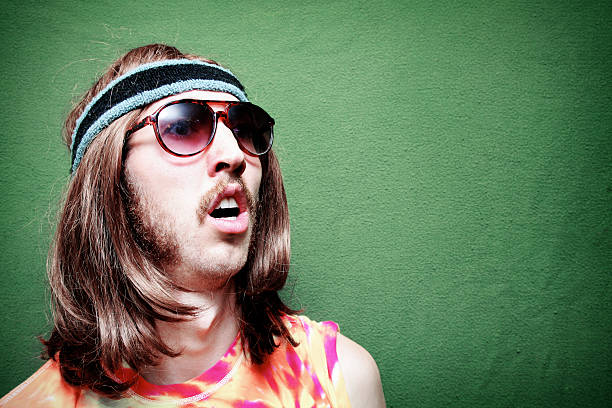 Surprised Hippy Man with Mustache and Long Hair A stereotypical hippy with Tie-Dyed Shirt, sunglasses, long hair, and mustache.  Horizontal with copy space. sweat band stock pictures, royalty-free photos & images